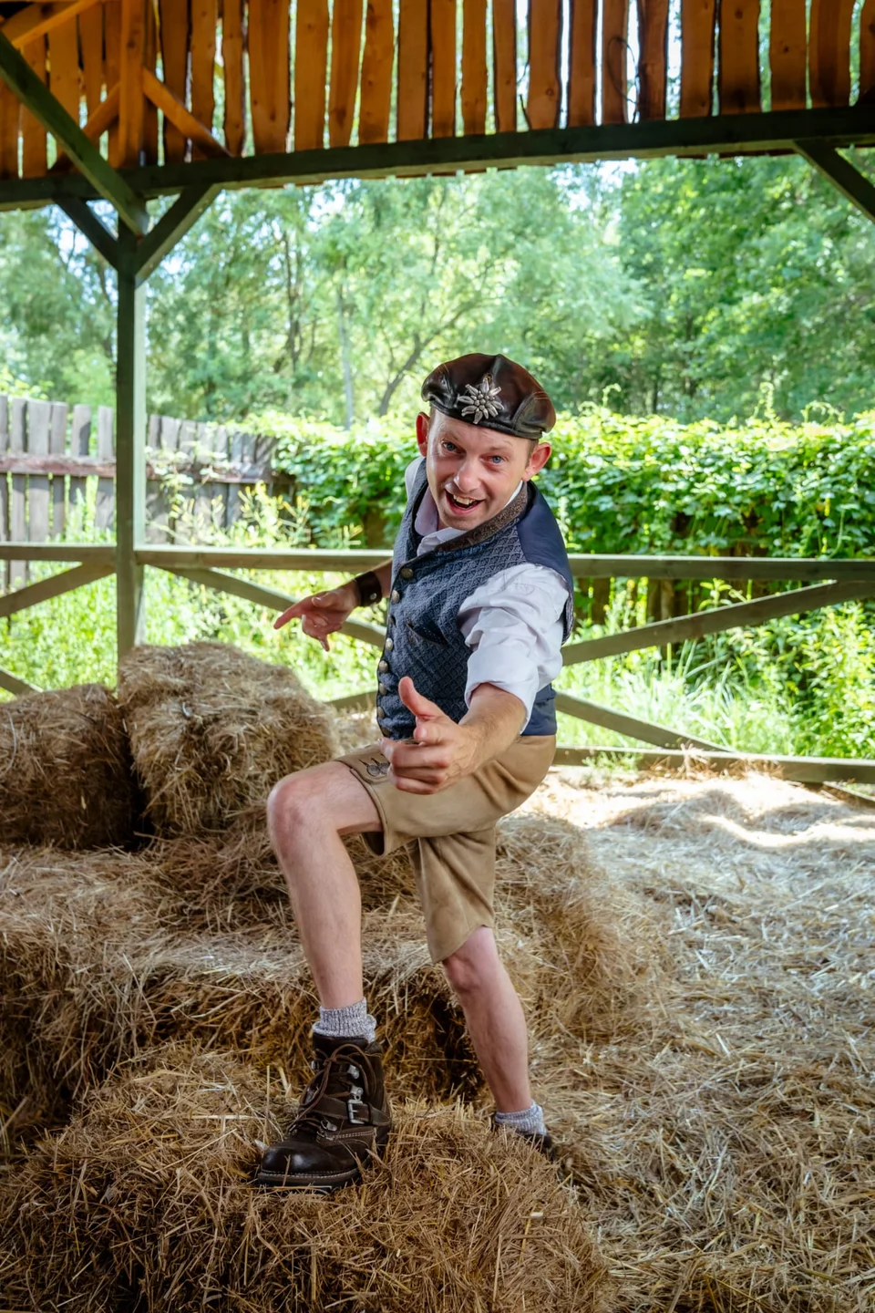 Spitzbua Markus in Tracht und Lederhose vor Heuballen – das vom Künstler bereitgestellte Originalfoto