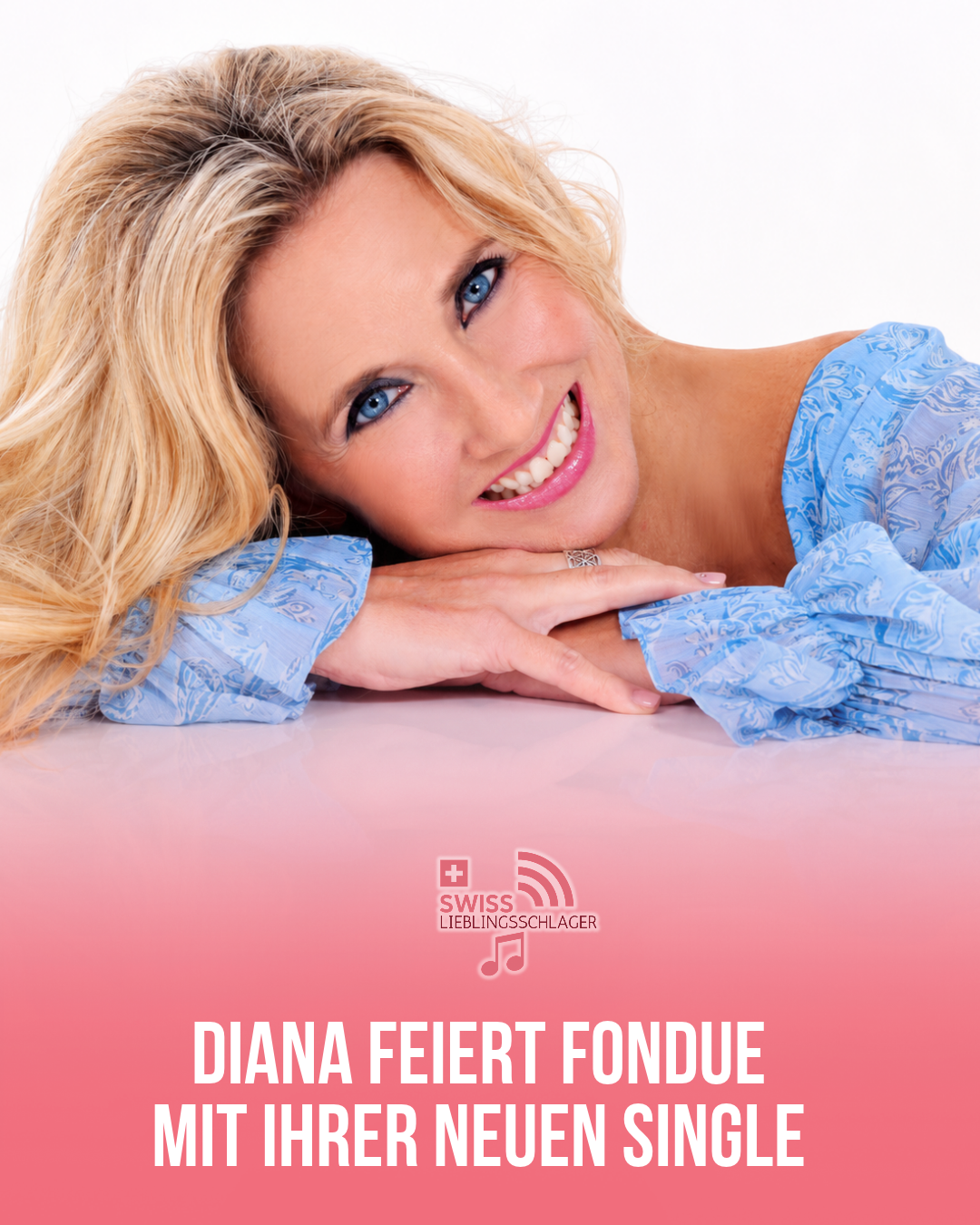 Diana lächelt im blauen Oberteil und legt den Kopf auf ihre gefalteten Hände.